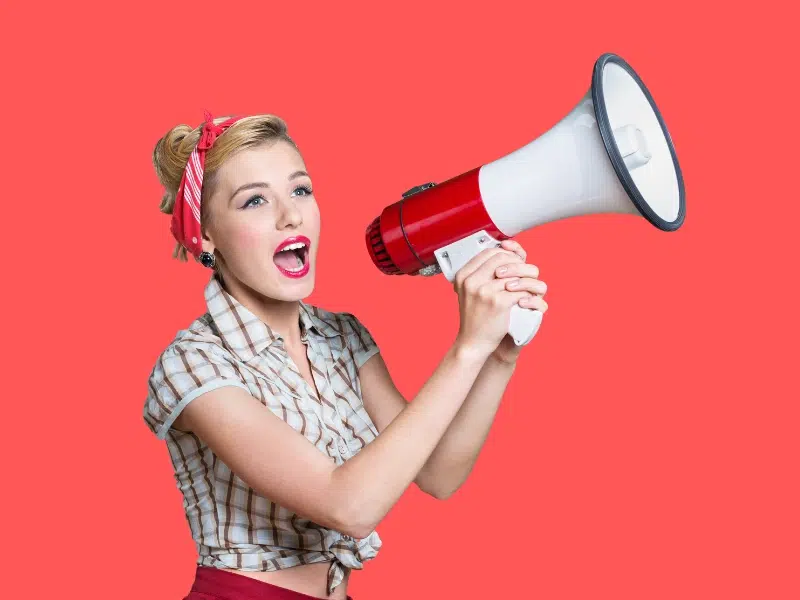 Woman using a megaphone to share a message about Honeycomb’s referral program
