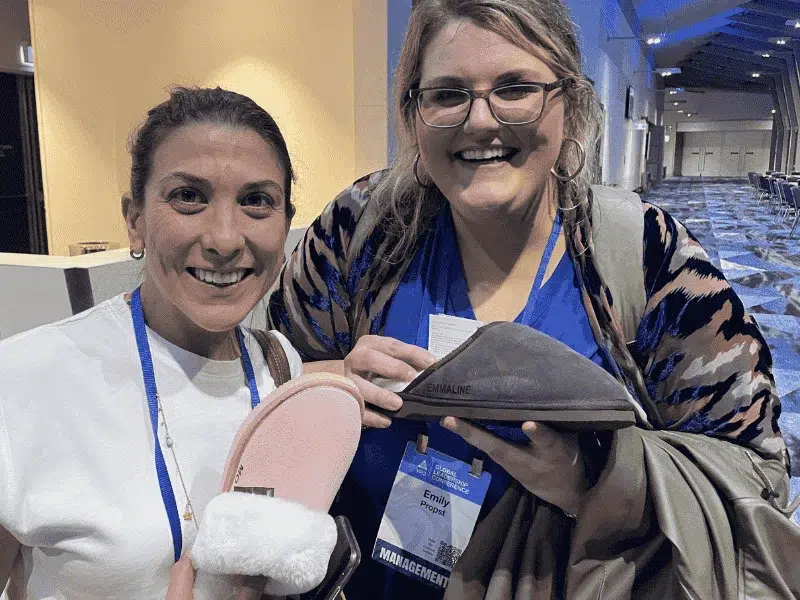 YPO delegates smiling and holding personalised engraved UGG boots at live on-site activation