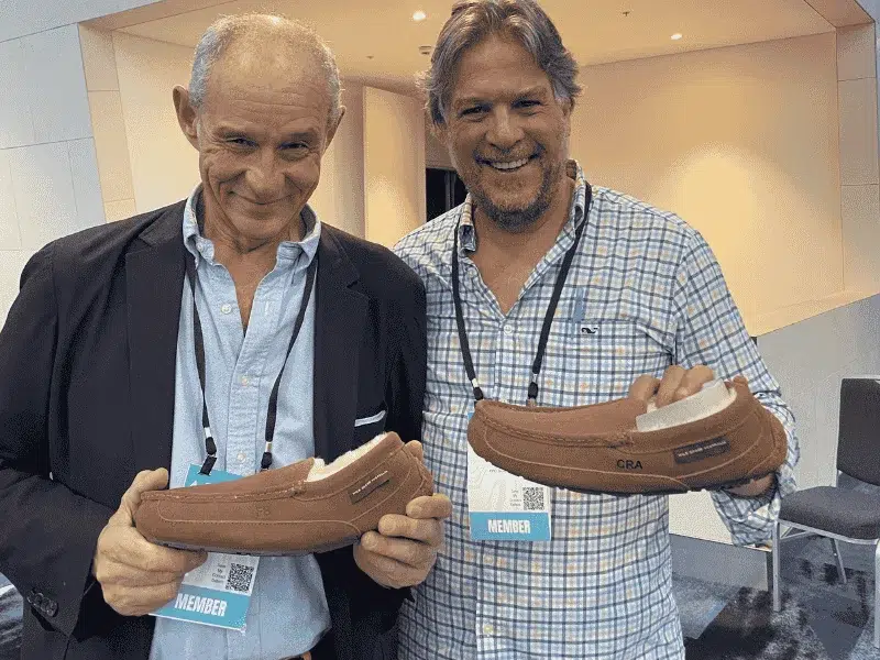 YPO members holding personalised engraved UGG moccasins during live activation