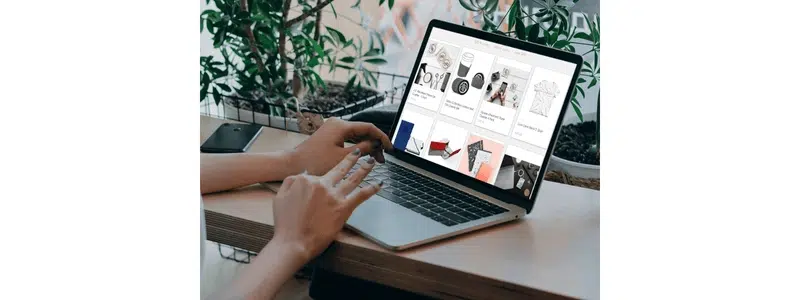 Person browsing an online pop-up store selecting branded merchandise on a laptop