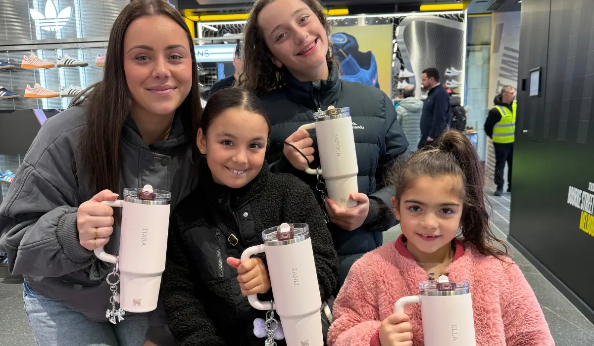 A group of young girls and an adult smiling with their personalised drink bottles