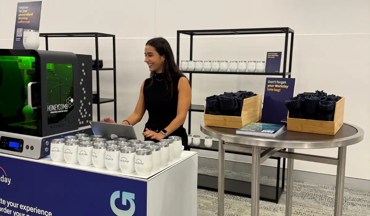 Honeycomb technician running a laser engraving station with personalised coffee cups at an end-to-end brand activation stand