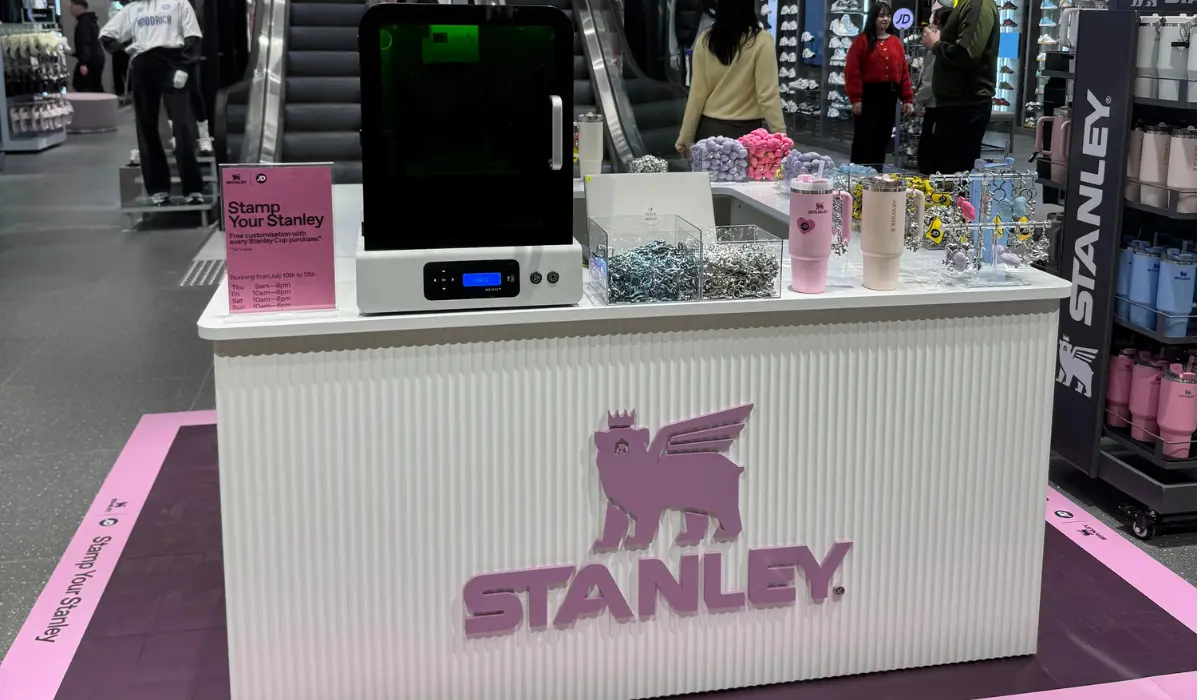 In-store brand activation stand with a laser engraver, personalised drink bottles and charms for customers to customise