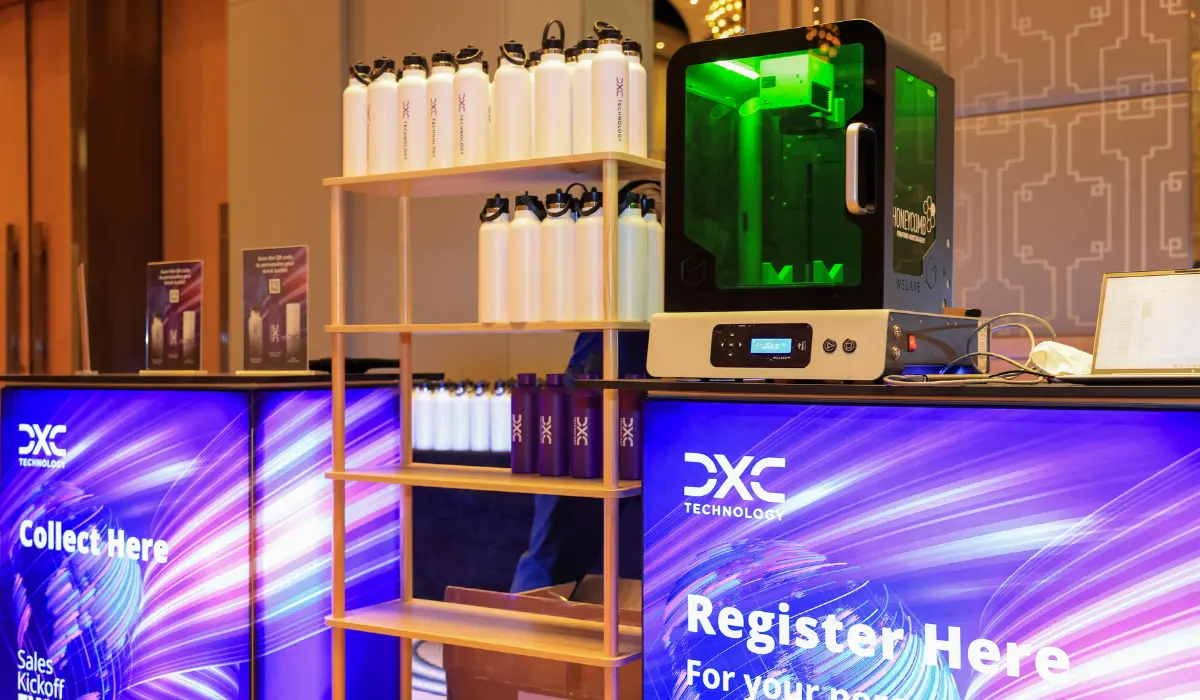 Personalised drink bottles and a laser engraver at a DXC Technology brand activation stand