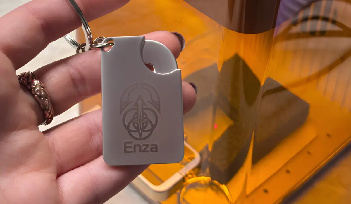 Guest holding a keyring engraved with the name Enza and a one-off AI-generated design