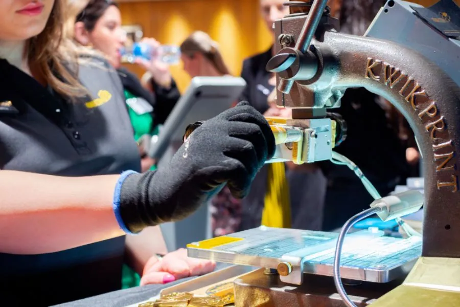 1 brand activation Staff member personalising merchandise on an engraving machine at a brand activation event