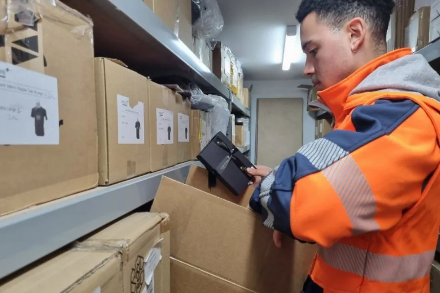 CLEVER CORPORATE STORES Warehouse worker in hi-vis packing branded merchandise orders for a corporate store