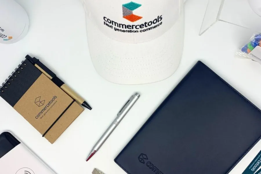 CREATIVE CORPORATE GIFTING Branded cap, notebooks, pen and tech accessories laid out as a corporate gift set