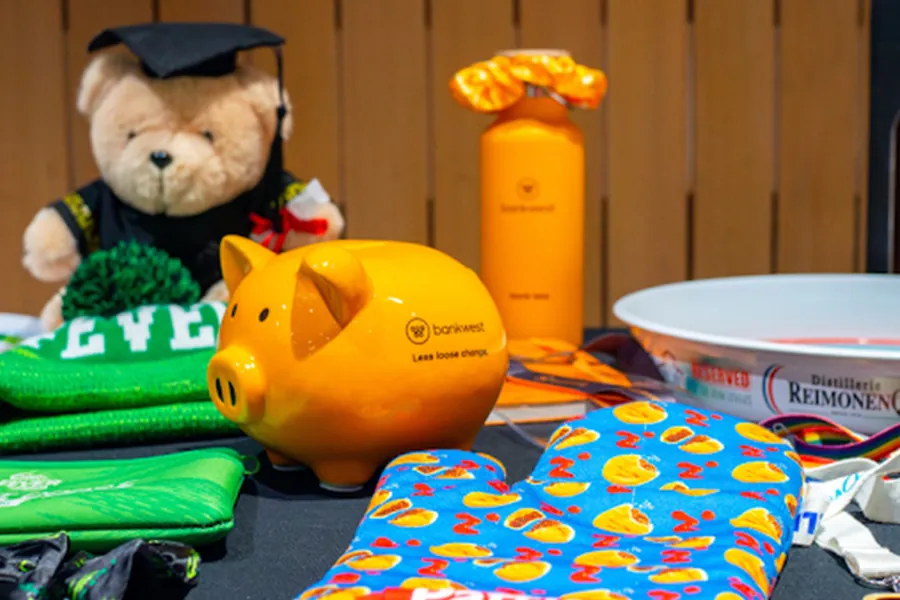 Employee-Welcome-Packs-Welcome-Panel Corporate welcome pack with a graduation teddy bear, branded piggy bank, drink bottle and oven mitt